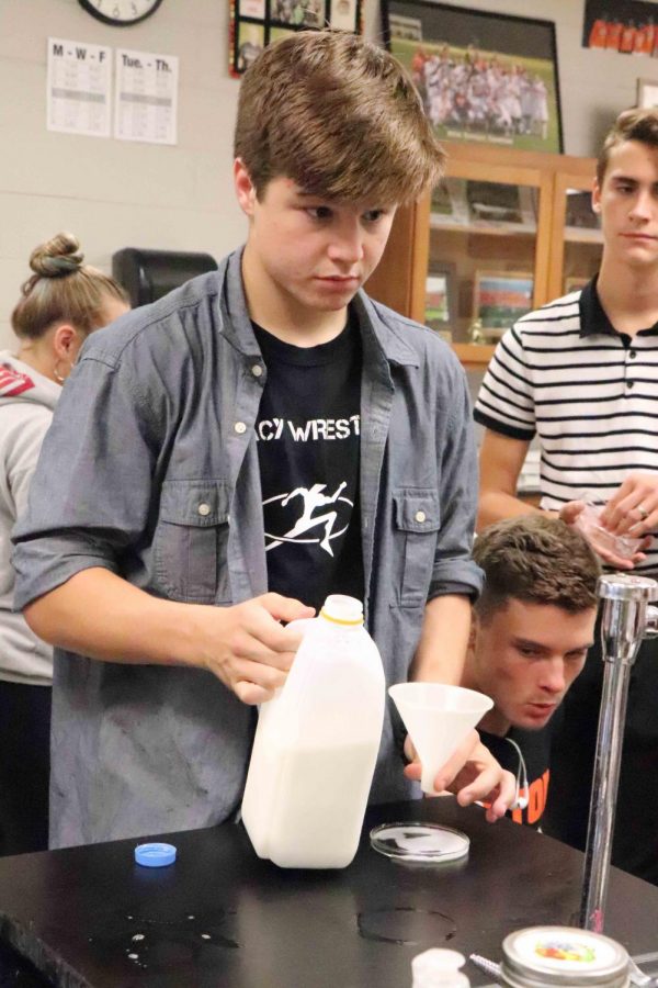 Measuring milk for a lab, sophomore Mason Church watches his classmate prepare their lab materials.  Biology classes are studying different fats and solutions in order to learn more about molecules and their reactions to certain chemicals.