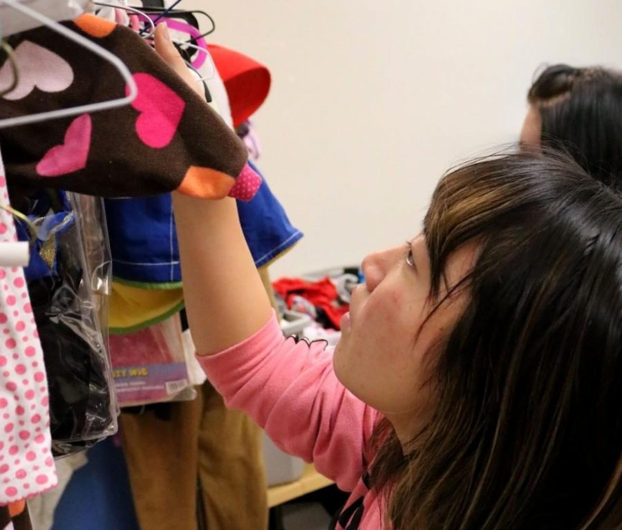 As she gives back the the community, japanese exchange student Yukari Kitamura hangs up clothes. Key club helped by volunteering at the share room on Oct. 2.