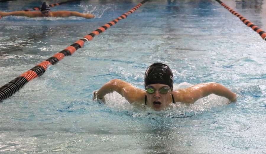 With her Owosso opponent behind her, freshman Abbey Carrigan finishes the 200 yard butterfly. Carrigan beat her opponent and the team came out on top during the meet on Sept. 29. 



