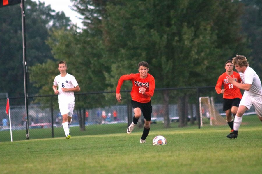 As he races toward the ball, freshman Ben Chapple tries to beat out his Goodrich opponents. The varsity soccer boys tied their game with goodrich 1-1 on Sept. 13.
