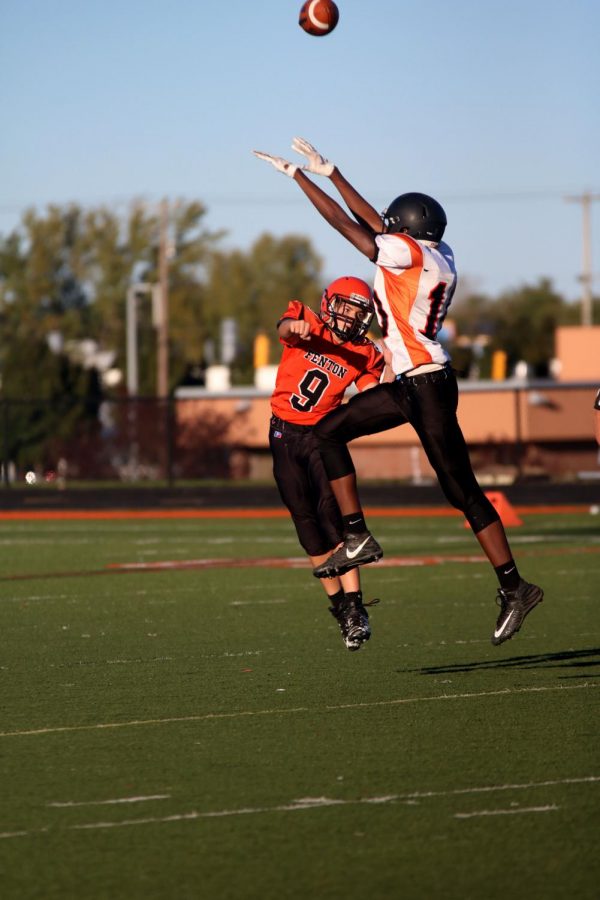 While freshman Seth Logan throws the ball to his teammate, Flushings defensive player tries to block the ball. The freshman Fenton football team played Flushing on Oct. 4.