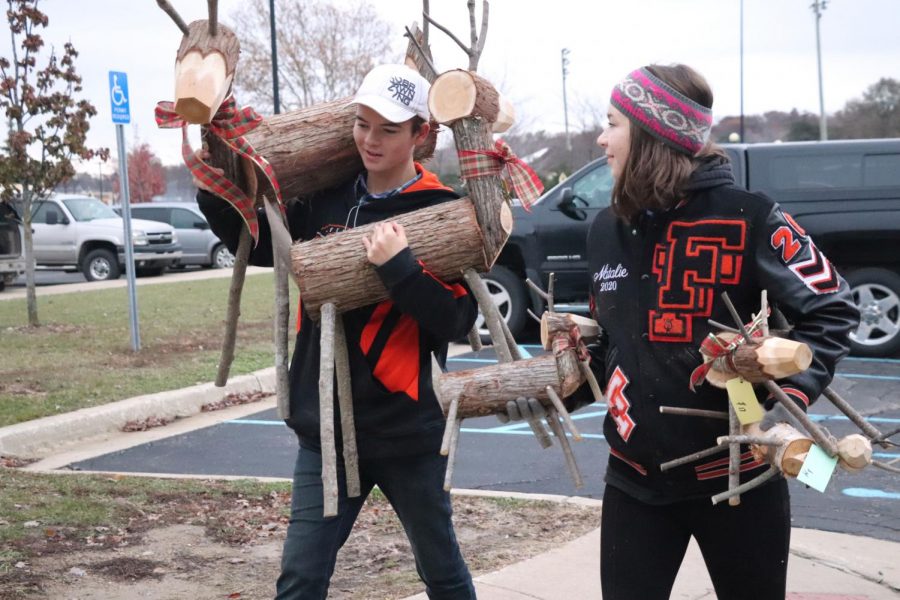 For the annual State Road Craft Show, junior Natalie Harmon helps set up a vendors wooden reindeer. On Nov. 18, NHS members helped get the school ready for one of the biggest art fairs of the year. 
