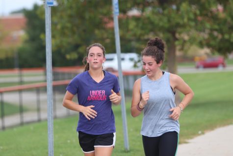 Freshmen Taylor Huntoon (left) and Angelina Vitarelli (right) run together during practice. Both girls are members of the Fenton cross country team