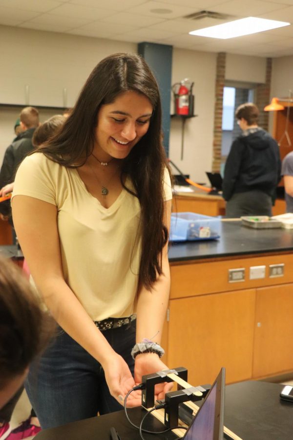 Hands out, senior Delaney Miesch gets ready to catch a hot wheel for a conceptual physics lab. Science teacher, David Sturms conceptual physics class tested the students knowledge of velocity in a projectile lab.