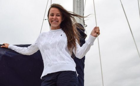 Senior Drew Follett stands on a sailboat as a part of her senior pictures. 