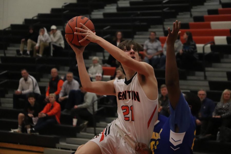 With the game coming to its final minute, sophomore Jacob Korzenowski jumps up in front of his opponent to draw a foul and still get his shot off and in. The Fenton JV boys basketball team ended up winning against Kearsley 54-45. 