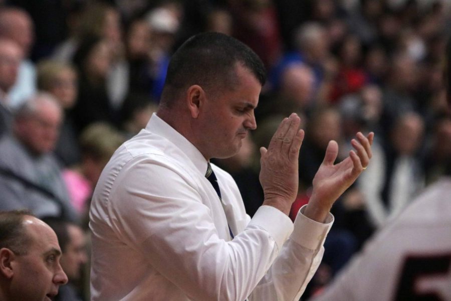 After the outcome of a play, varsity basketball coach Chad Logan claps and cheers for the varsity boys basketball team.  The boys basketball team played Linden on Jan. 18.