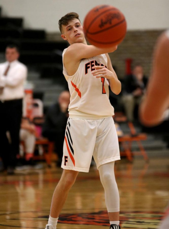 As the boys varsity basketball team plays Owosso, junior Trent DeGayner passes the ball to his teammate. The boys varsity basketball teams last home game is Feb. 22 against Linden.
