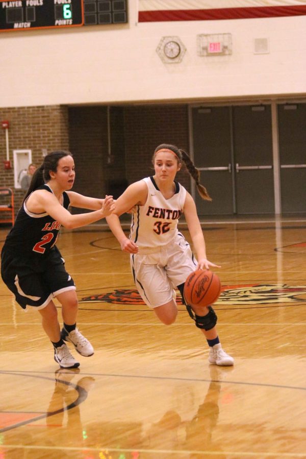 Dodging her Linden opponent, sophomore Maggie Lutz rushes down the court to score a basket fer the JV basketball team. The JV girls basketball team played Linden on Feb. 21.