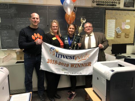 Senior Cami Tiemann and Finance teacher Bruce Burwitz pose with representatives from Investwrite after Tiemann was awarded eighth in the nation for her essay. All of Burwitzs classes wrote a paper earlier in the year giving advice to entrepreneurs about how to invest their money.