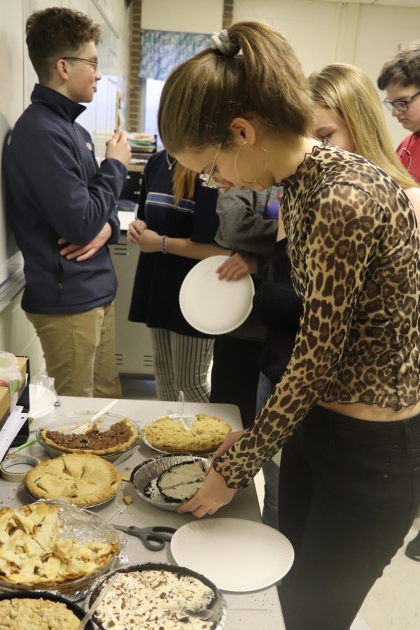 Senior Elizabeth Maxwell grabs a slice of pie from the table. Math classes celebrated Pi Day on March 14 by eating pies. 