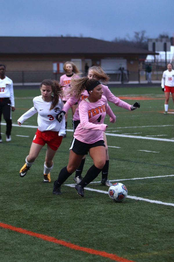 While she gets away from the defender senior Kirty Foor looks up to pass the ball. The girls varsity soccer team played Swartz Creek on April 2.