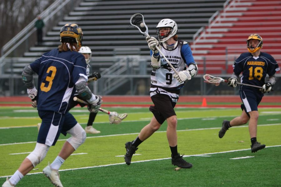 Junior Hunter Higginbotham catches the ball, ready to make a shot. On April 4, the Fenton-Linden boys lacrosse team played Ovid-Elise, winning 10-4.  