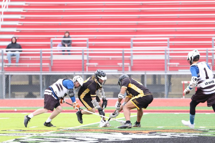 While lowering his shoulder to hit his defender, junior Jason Thompson tries to get possession of the ball. The fenton/Linden Wolves defeated Bishop Foley 15-4 on April 2nd. 