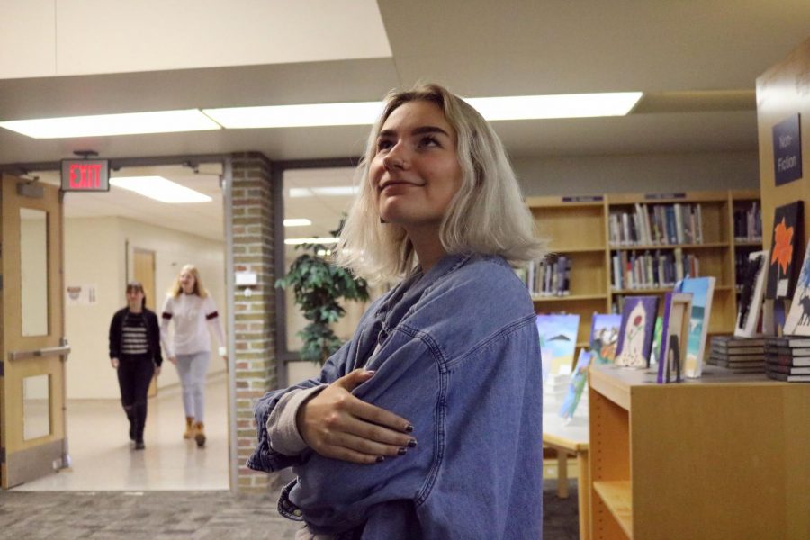 Stopped to admire the art, senior Noelle Nixon walks around the art show. The art show took place in the media center on Apr. 25.