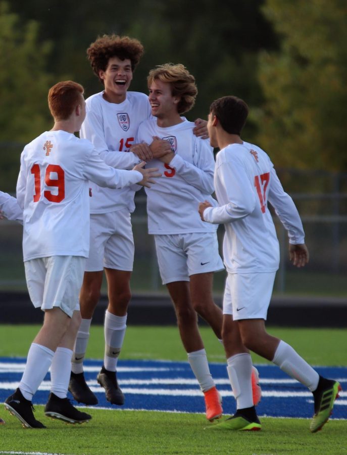 Jumping up and down, junior Max Guerra celebrates a goal with his teammates. On Sept. 23, the boys varsity soccer team played Lake Fenton, winning 8-0. 