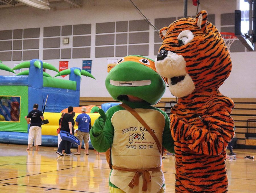 Junior Jake Gurnsey dresses up like a Ninja turtle at Key Clubs’ Pancake Breakfast. He dressed up to perform in a skit and advertise for Fenton Karate. Erika Behnfeldt dressed in the Fenton tiger mascot to show Fenton pride and to take pictures with the children. On September 7, 2019, Key Club hosted a pancake breakfast at AGS Middle School. There were flying pancakes, a karate show, and a special performance by the Fenton High School drumline.   