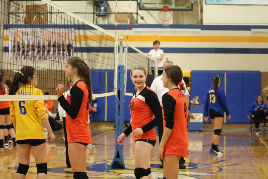 Freshman Grace Pierle laughs with her teammate. On Oct. 16, the Freshman Girls Volleyball team won all 3 of their games against Flint Kearsley.