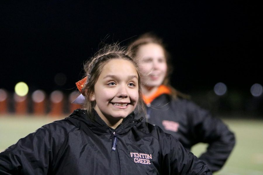 Freshman Bri Hale smiles as they yell their cheer. On Oct. 24 Fenton verses Walled Lake Northern for the last game of the season. 