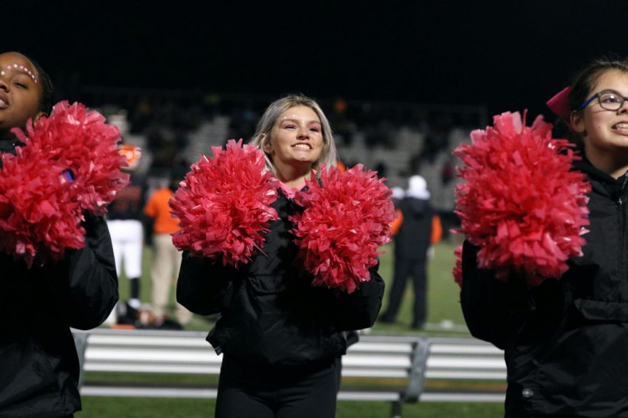 Junior Varsity cheerleader Brianna Bennett smiles as she cheers for the varsity football team. On Oct. 25, the Tigers defeated Walled Lake Northern 58-7.
