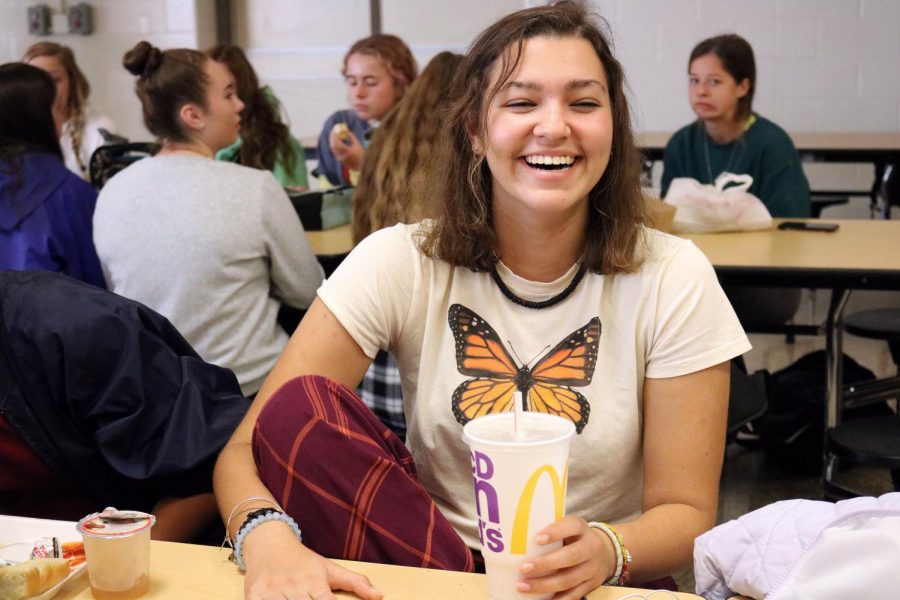 For spirit week, junior Jordan Wensley dresses up as someone from the 1960s for decades day. On Oct. 8, Jordan Wensley laughed with her friends during lunch. 