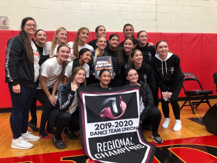 Posing for a picture, the Fenton High Adrenaline Dance team smiles with their newly won awards. The team attended a competition on Nov. 2 at Grand Blanc High School.