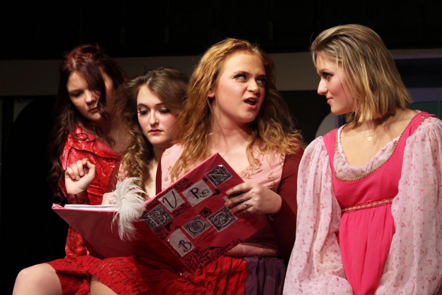 The burn book has been pulled out and the cast of Much Ado About Mean Girls huddles around reading the pages. IB theater performed this play Nov. 7 through 9. The play is about Cady, the new girl in school finding her way when the mean girls befriend her.