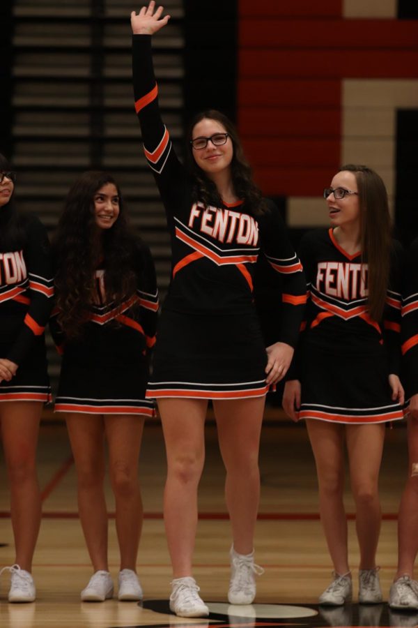 As her name is called for varsity Competitive Cheer, freshman Sophia Wagner waves to the crowd. The winter Meet the Team was held in the gym on Nov 25. 