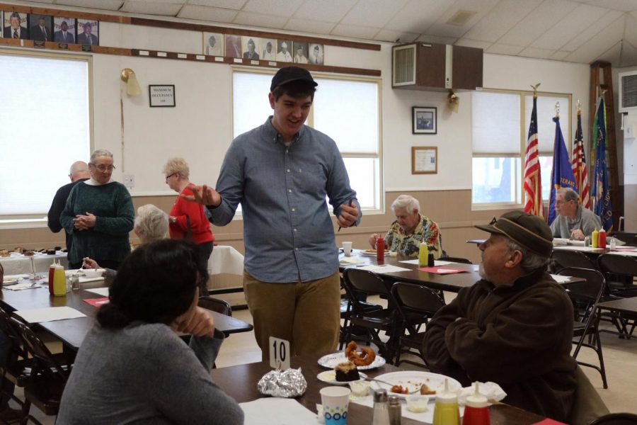Junior Joe Henley talks to customers at the Fenton Veterans of Foreign Wars (VFW) building. On Feb. 14, National Honor Society (NHS) members volunteered at the VFW by taking orders and serving food. 