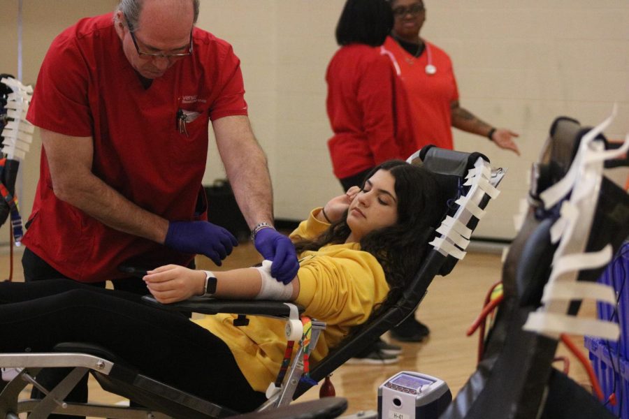 Getting her arm taped, junior Anna Ebert waits patiently after getting her blood drawn. On Mar. 9, FHS hosted a blood drive.