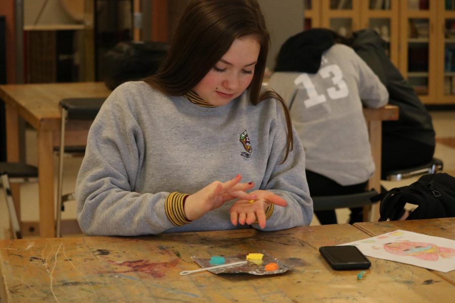 Junior Maddie Kazmierski participates in her art class. On Feb. 28 sculpture and drawing students make clay mask. 