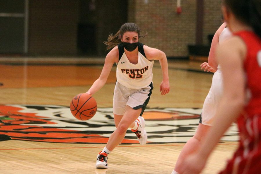 Sophomore Sophia Hense dribbles the ball and attempts to score for her team. On Feb 17 the Fenton girls varsity team took a tough loss against Holly 50-51.