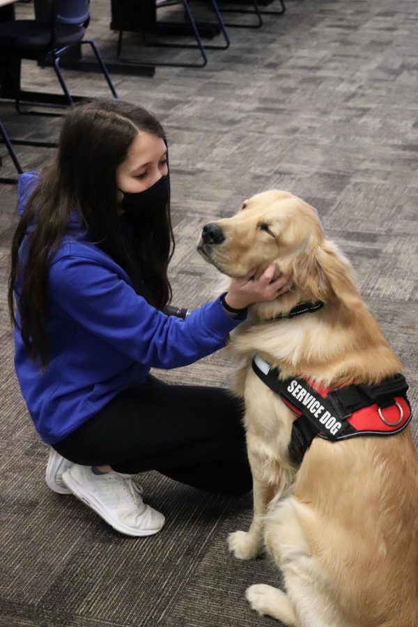 Sophomore Kaitlyn Mossett pets Sunny on Feb. 26 during a lifestyle shoot in her yearbook class.