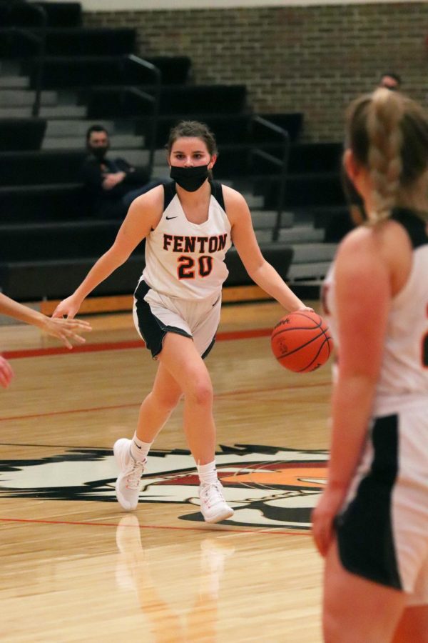 Looking for a teammate to pass to, sophomore Abby Logan dribbles the basketball. On March 3, the varsity girls team won 47-15.