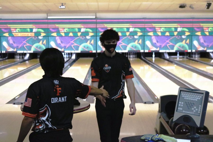 Approaching his teammate junior Nate Dymond gets a high five. On Mar. 13 the boys bowling team had a match ate Cherry Hill Lanes. 