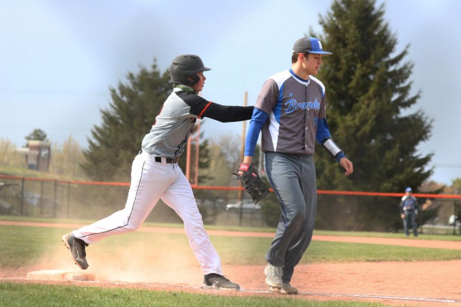 Running into first base, sophomore Zach Decracker pushes the first baseman out of the way. On Apr. 26 the JV baseball team defeated the Brandon Blackhawks. 