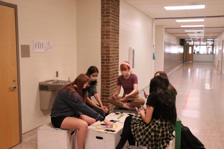 Fenton High School students play a card game in the hallway on the last day before exams. 