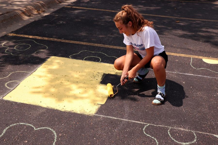 Senior Riann Masi rolls paint on her parking spot. This year, students were very excited to be able to paint their spots and express their creativity.