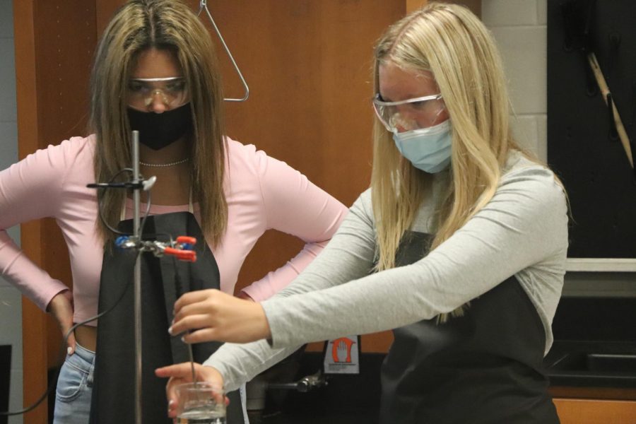 Freshmen Maddie Knight and Sophia Kildee work on a boiling water lab in Physical Science teacher David Sturms class on Sept. 9. During this lab, students learned how to graph water temperature changing from cool to boiling in a short amount of time.