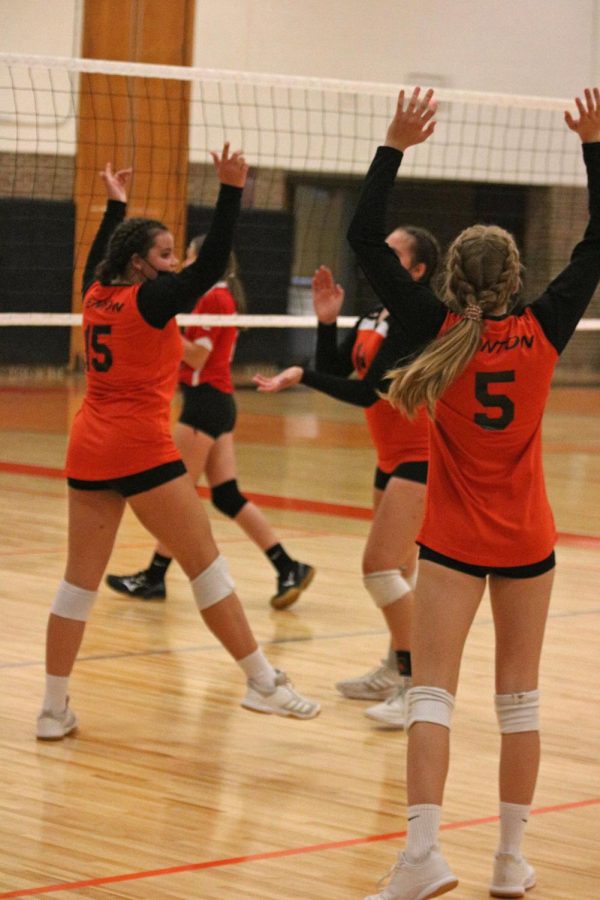 Celebrating a point, freshman Anna Logan, Abby Gonzales, and Korryn Roberts cheer on their team. On Sept 14. the Tigers beat the Swartz Creek Dragons in all three sets. 
