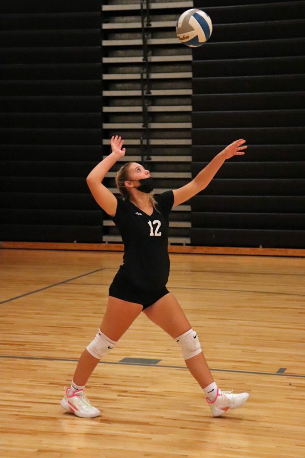 Preparing to make contact with the ball, Freshman Kaylee Kaluza serves to the Kearsley Hornets. On Sept. 22 the Tigers beat the Hornets in all three sets. 