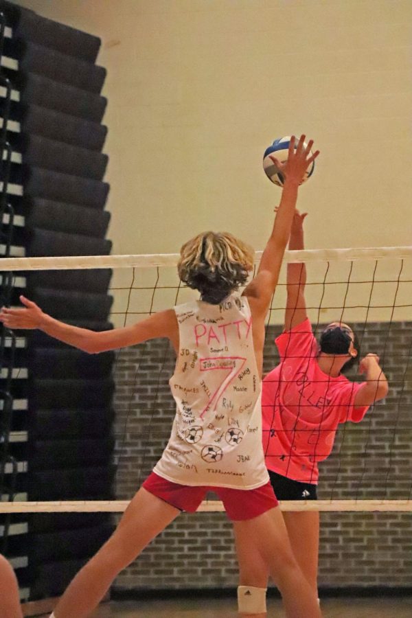 Sophomore Paige Bakker attempts a spike as junior Patrick Hamilton blocks it. On Sept 21. the girls volleyball program played against the boys soccer program, raising money for a local family battling cancer. 