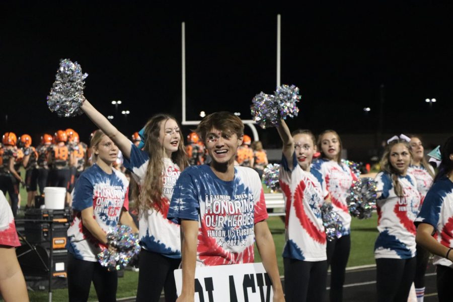 Cheering for his team, Junior Alex Brelin is saying the cheer Orange and Black to engage the student section. On Sept. 10, the team cheered on the varsity football players as they took on Flushing.