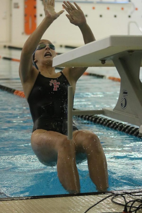 Reaching back, junior Sophie Stefanac pushes off the wall to start her backstroke race. On Sept. 11 the Tigers defeated Livonia with a close score. 