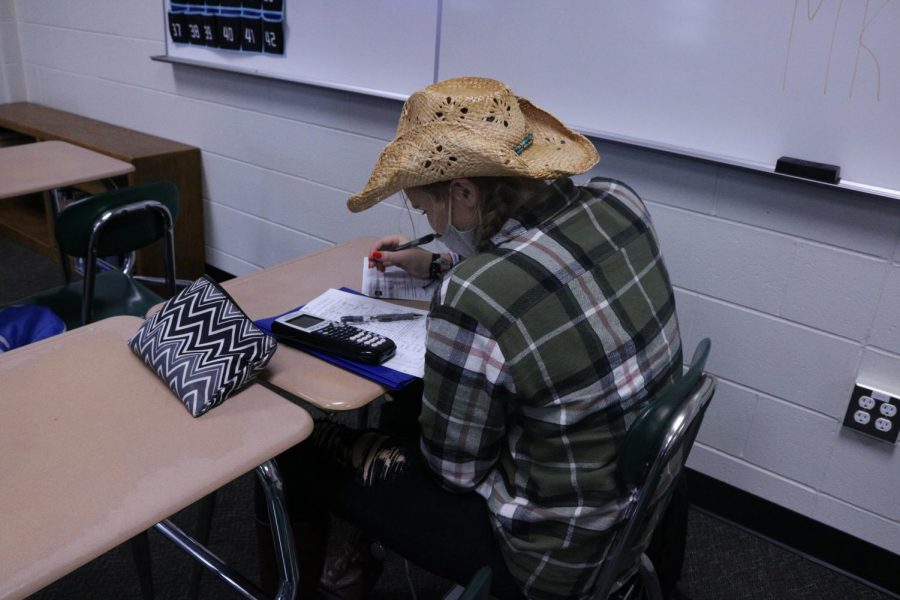Meghan Maier is dressed up as a cowgirl and is work in Sarah Sahrs math class. On Oct. 20, the homecoming spirit day theme was country vs. country club. 