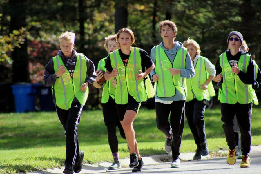 Junior Carson Tiemann runs alongside his cross country teammates during the ball run. On Oct. 22, the cross country team made their journey from Walled Lake Northern HS back to Fenton High to deliver the homecoming game ball to the varsity football team.