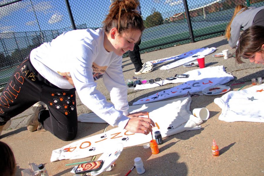 Junior Maddie Burnau laughs with her friends while painting sweatpants. On Oct. 17, the junior class painted sweatpants for their powderpuff game the next day. 