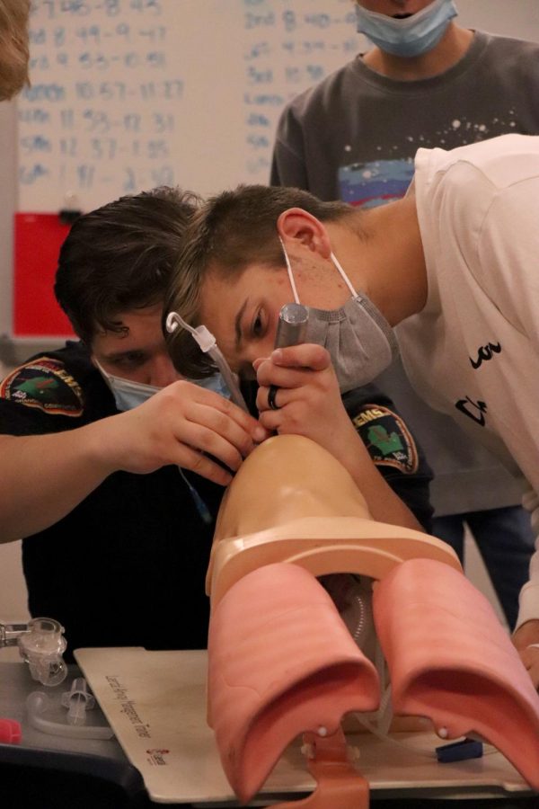 Watching alumni Kyle Podeszwiks instructions, junior Caleb Markley learns how to intubate someone. On Nov. 9, 6th hour forensics students welcomed a guest speaker who discussed what it was like to be an EMT.  