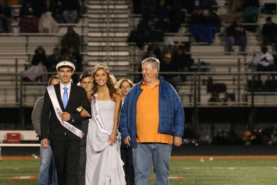2020 Homecoming King and Queen Taylor Farrell and Brody Stack walk down the football field with retired FHS teacher Steven Karr. On Oct. 22, Farrell and Stack crowned the 2021 Homecoming King and Queen, seniors Kylie Schramkee and Chase Gibson.