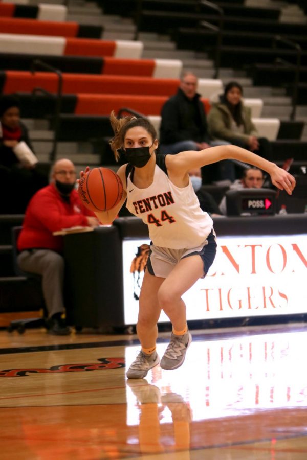 Looking out for a Grand Blanc opponent, junior Madison Slezinski charges for the hoop. Slezinski made the first point for Fenton in the first game of the season on Dec. 7. 